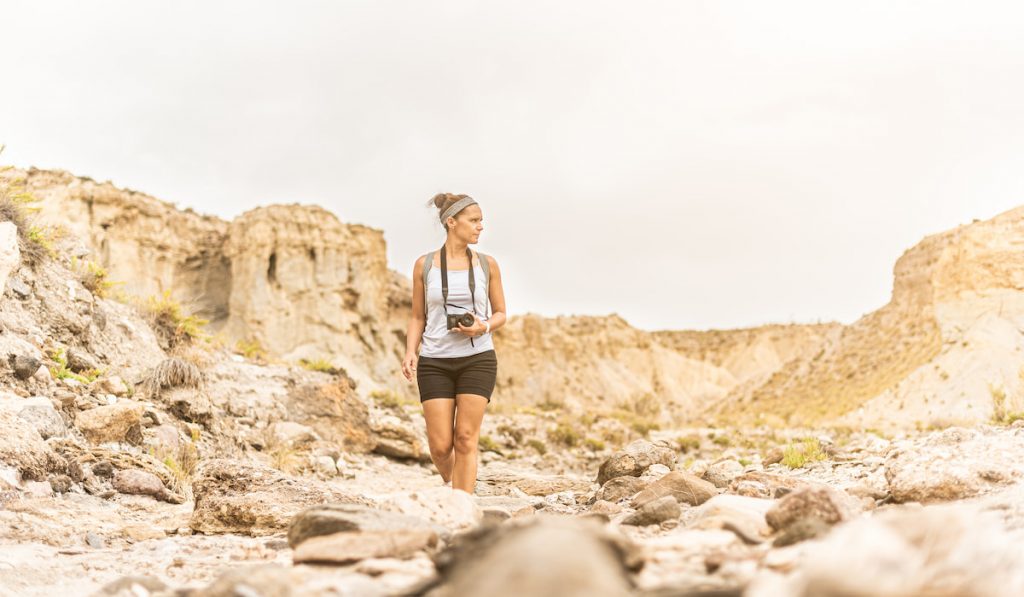 Archaeologist  standing in mountainous terrain in desert