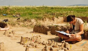 Archeologist-working-on-site-with-her-documents