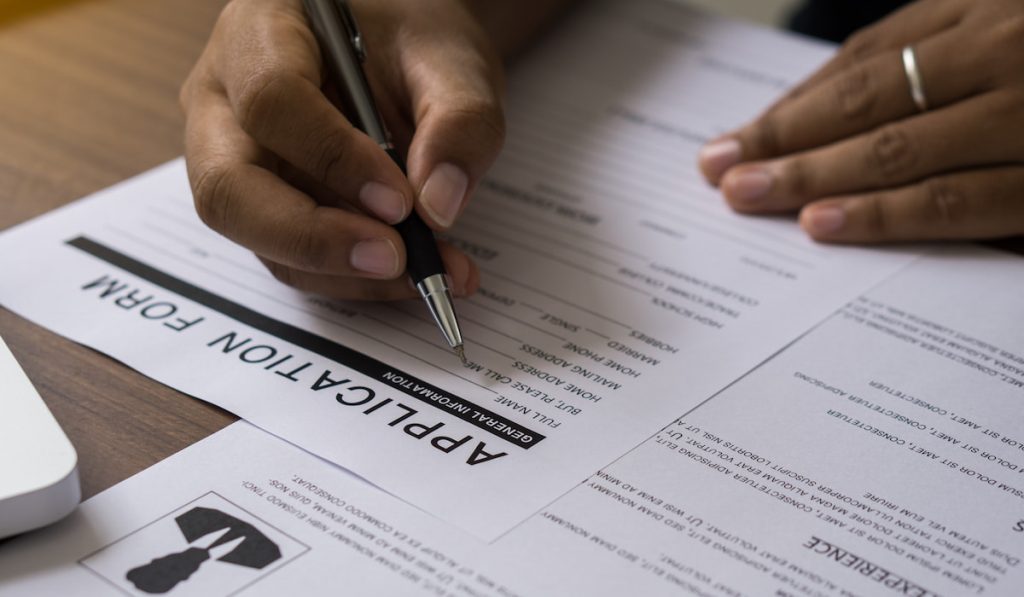 Hand of man writing personal profile and review resume to applying for job