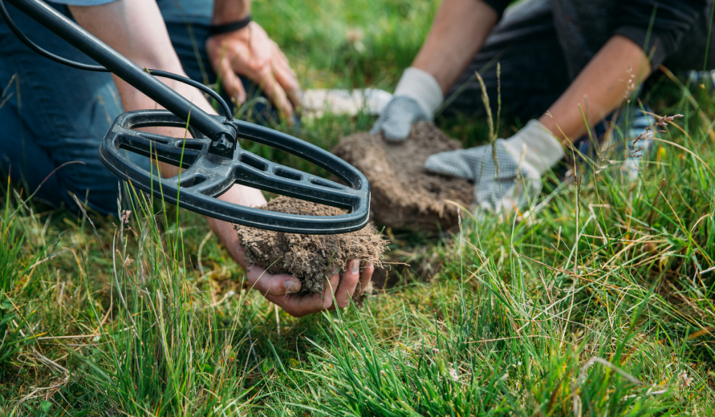 Metal detector searching for treasure in the ground.
