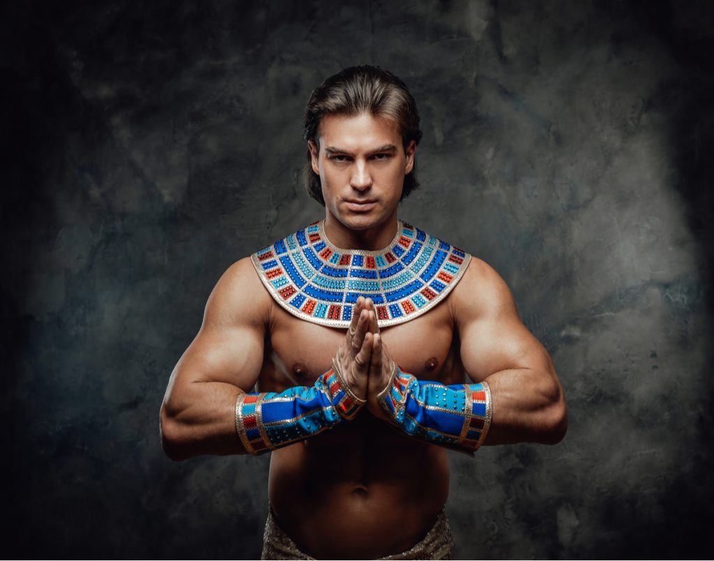 man wearing ancient egyptian clothing on black background 