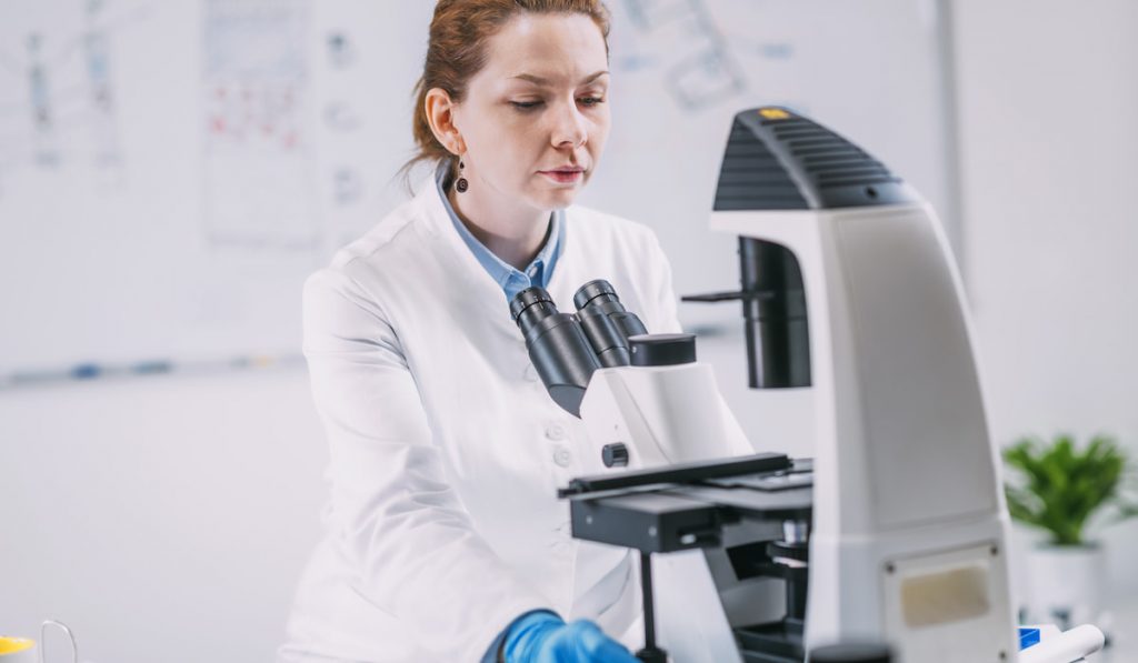 Portrait of Young Female paleontologist with Microscope